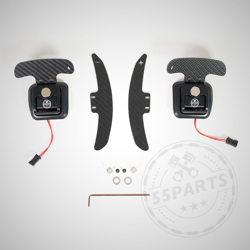 55Parts Spezial: Magnetisches Schaltwippen-Kit V2 (E9X M3) inklusive Carbonfaser-Wippen, Schrauben, Verkabelung und Inbusschlüssel. Rennsport-inspiriertes Design auf weißem Hintergrund.