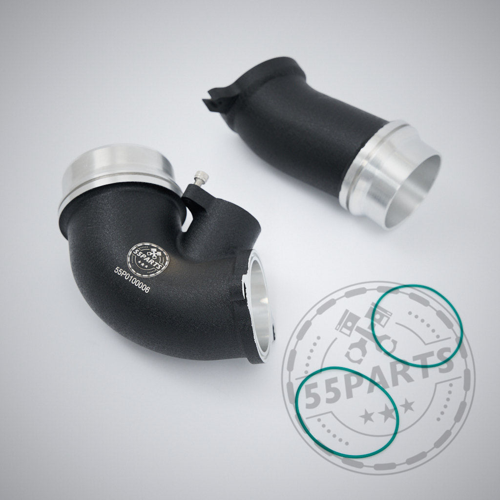 Zwei schwarze und silberne 55Parts High Flow Turbo Inlet Reinluftrohre für BMW G87 M2, G80/G81 M3, G82/G83 M4 S58 liegen auf einem hellgrauen Hintergrund mit verblichenem 55Parts Logo; inklusive Teilegutachten für Qualität und Konformität.
