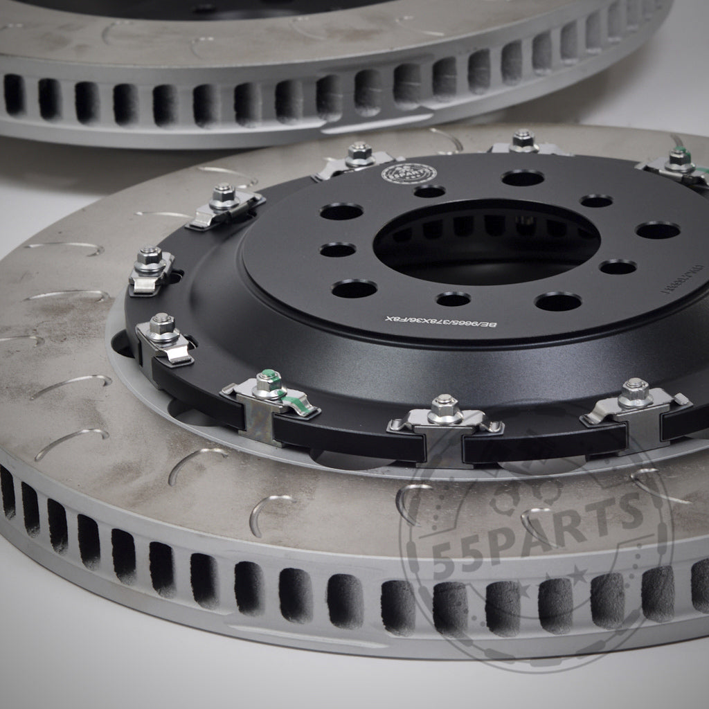 Nahaufnahme von zwei 55Parts Special Aftermarket Ersatz-Reibringe J-Hook für AP Racing Bremsanlagen-Bremsscheiben mit belüfteten Scheiben und schwarzen Mitten, ideal für die BMW-Leistung auf der Rennstrecke, vor einem hellen Hintergrund.