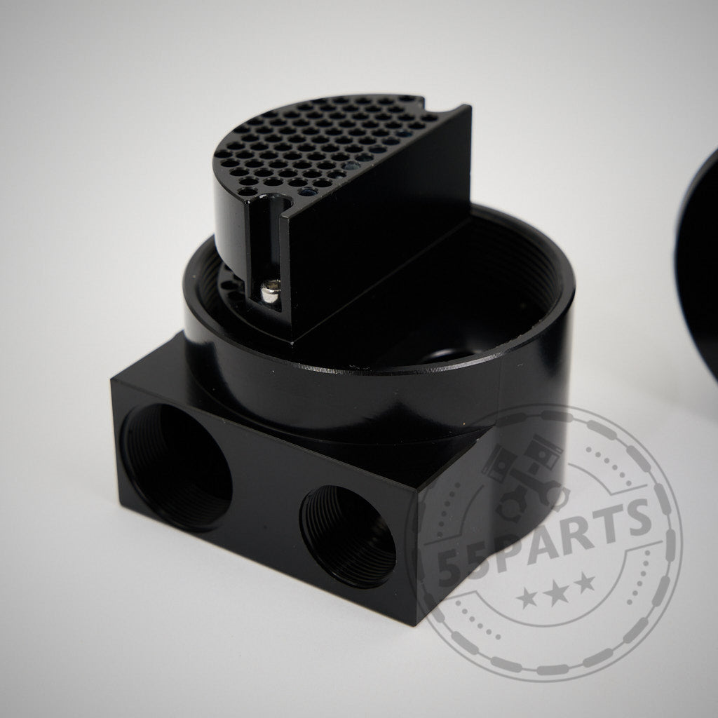 Der spezielle Ölauffangbehälter, der für die Modelle BMW F8x M2C, M2CS, M3 und M4 S55 entwickelt wurde, verfügt über ein schwarzes Metallgehäuse mit mehreren Gewindeanschlüssen und einem herausnehmbaren perforierten Einsatz zur Optimierung der PCV-Systembelüftung.