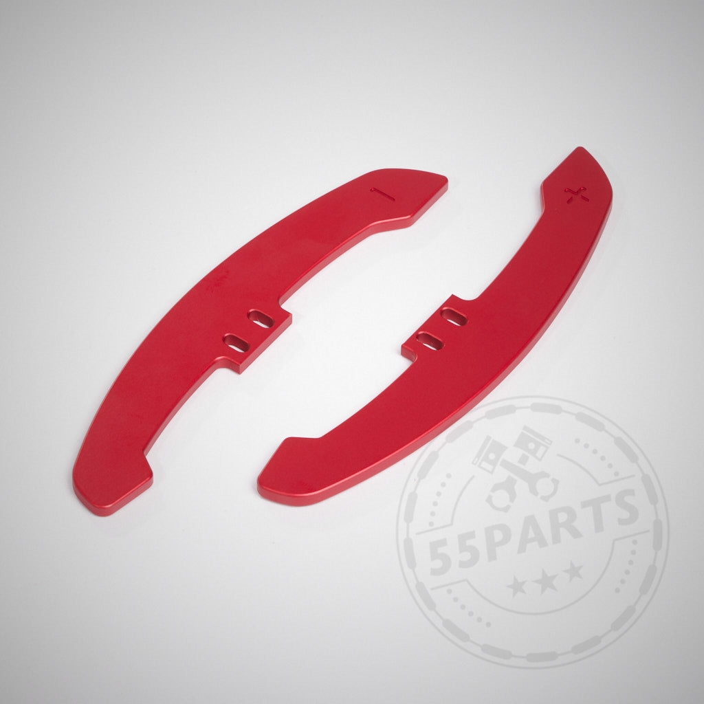 Zwei rote, CNC-gefräste magnetische Schaltwippenerweiterungen aus Aluminium Special mit Plus- und Minussymbolen auf hellgrauem Hintergrund.