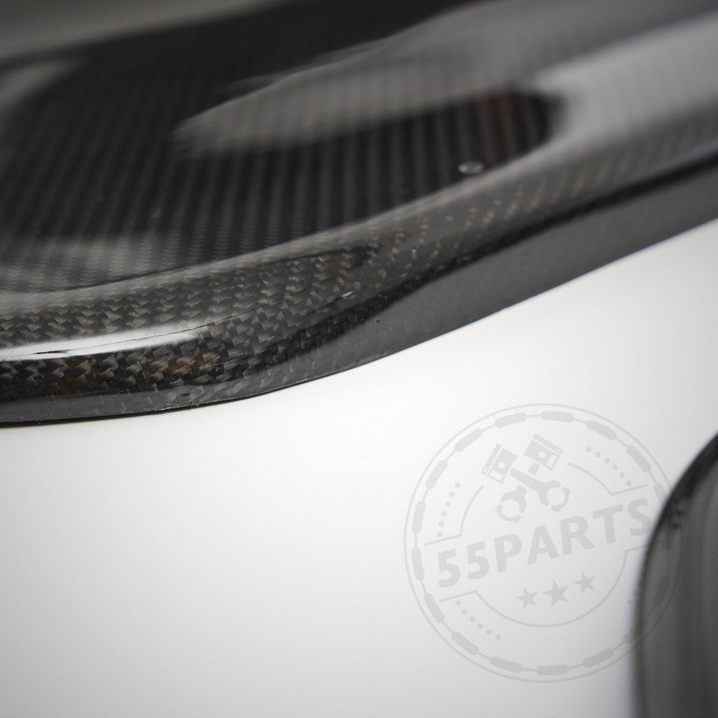 Nahaufnahme der 55Parts Carbon Türverkleidung Türpappen passend für BMW E92/E93 inkl. M3 auf einer weißen Oberfläche, die die Qualität und Passgenauigkeit dieser Premium-Carbon-Autoteile hervorhebt.