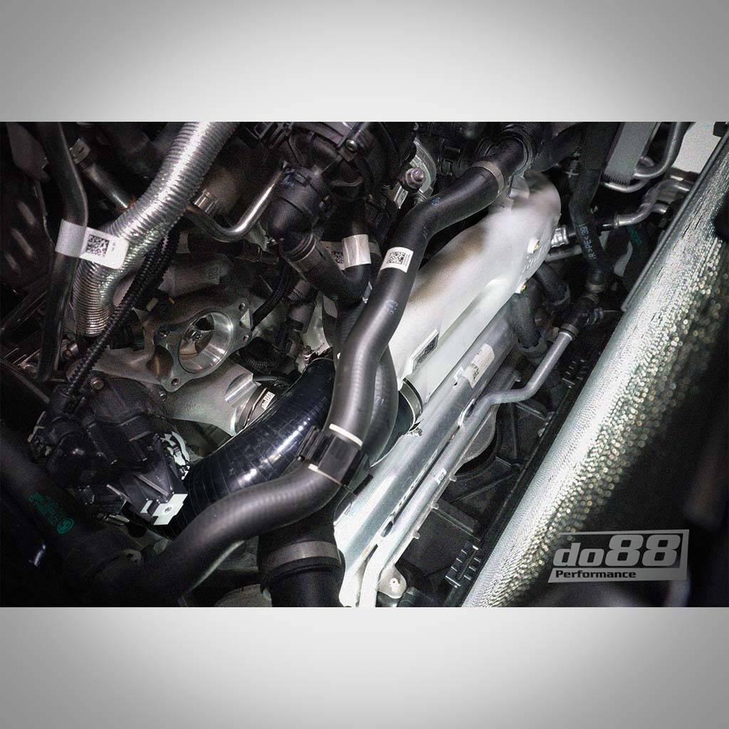 Nahaufnahme des Motorraums eines BMW G8X S58 mit Schläuchen, Komponenten und der DO88 Aluminium-Ladeleitung für die Modelle BMW G87 M2, G80/G81 M3 und G82/G83 M4 S58. In der Ecke ist das do88-Logo zu sehen.