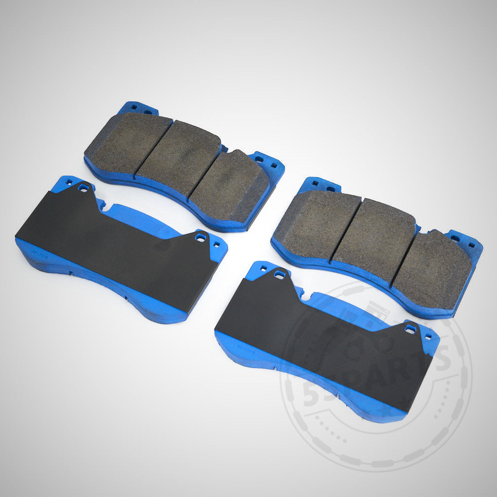 Vier blau-schwarze Endless Bremsbeläge passend für BMW G80, G81, G82 und G87 (M2, M3, M3 Touring, M4) von Endless sind auf weißem Untergrund angeordnet.