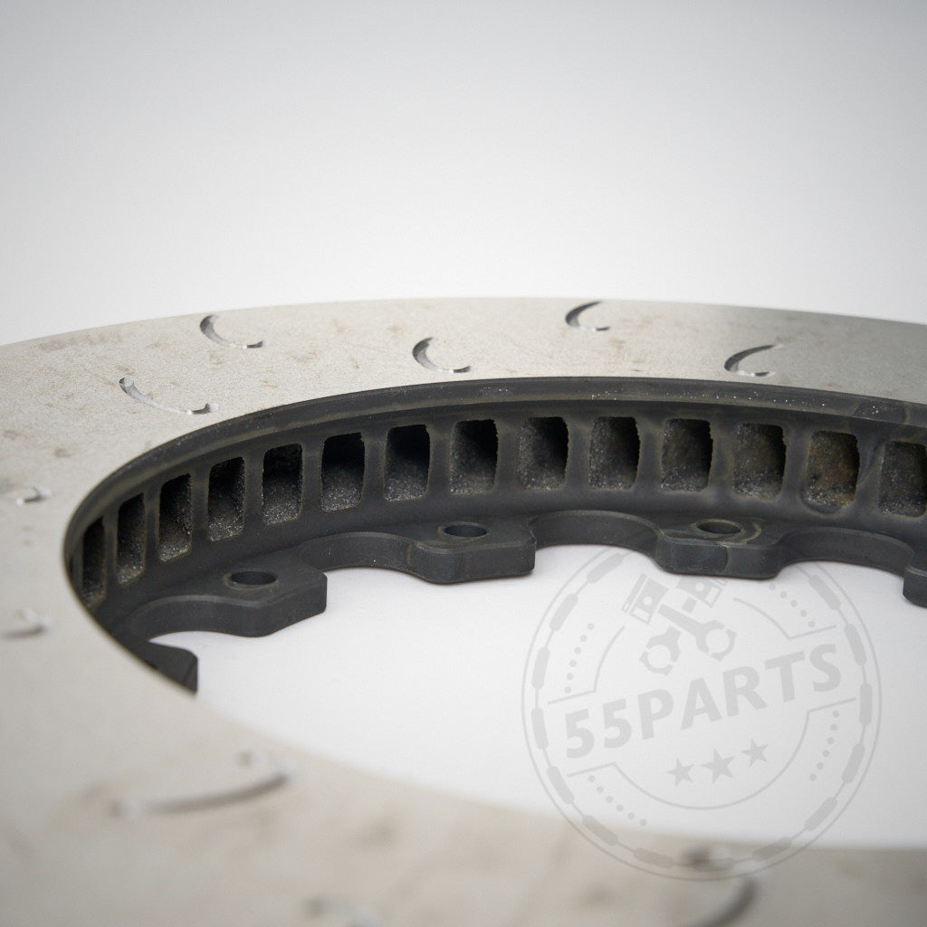 Nahaufnahme des 55Parts-Sonderangebots: Aftermarket-Ersatz-Reibringe J-Hook für AP Racing Bremsanlagen mit gerillter, belüfteter Bremsscheibe für den Einsatz auf der Rennstrecke. Das 55Parts-Logo ist unten rechts teilweise sichtbar.