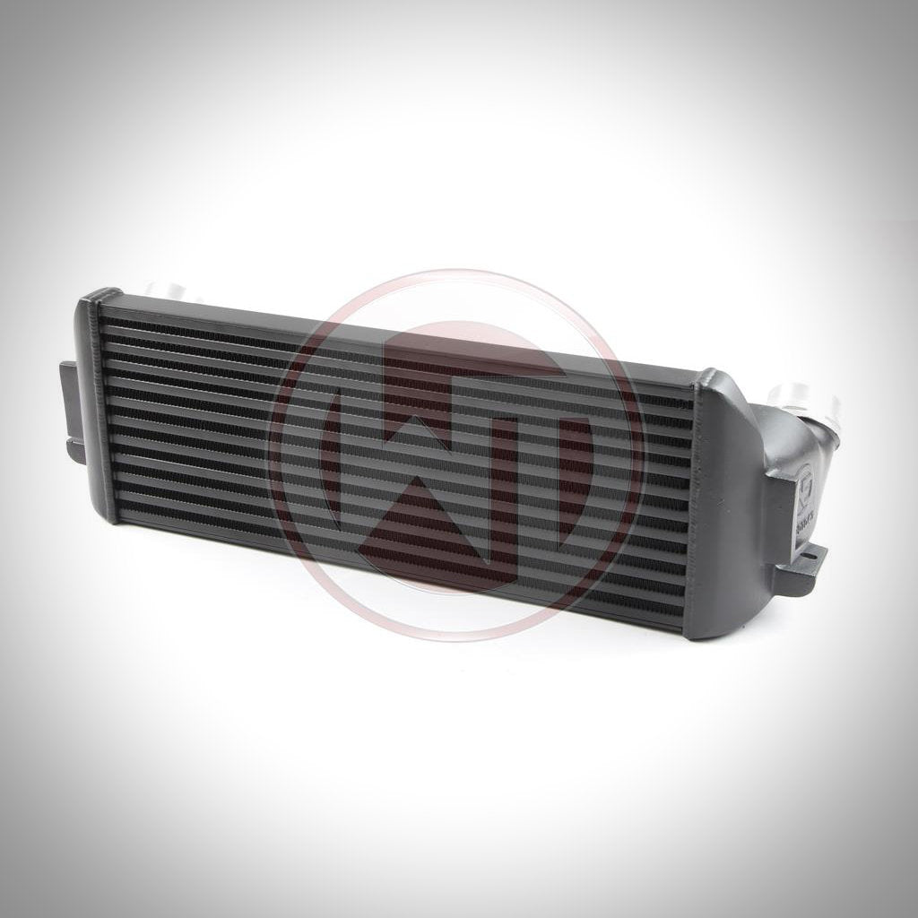 Der Wagner Evo 1 Competition Ladeluftkühler passend für BMW F2x, F3x von Wagner Tuning wird mit Endkästen auf weißem Hintergrund mit WT-Logo-Wasserzeichen abgebildet.