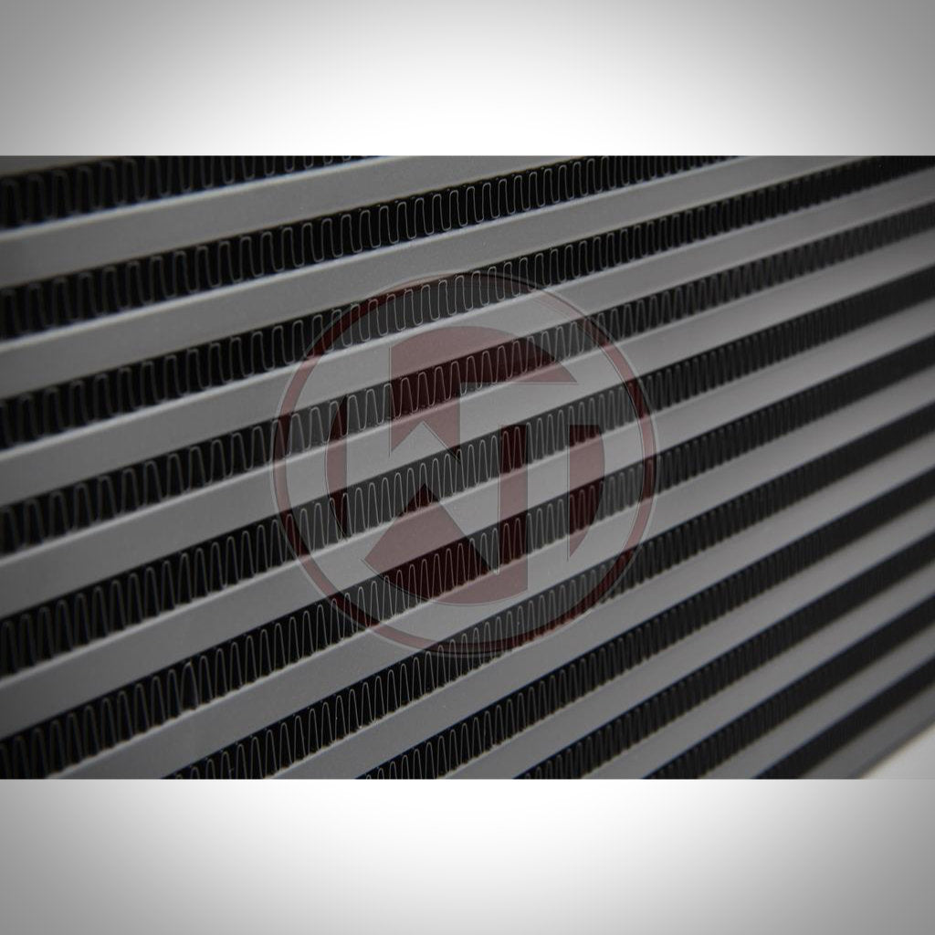 Nahaufnahme des Wagner Tuning Evo 1 Competition Ladeluftkühlers passend für BMW F2x, F3x mit parallelen horizontalen Lamellen und Schlitzen, die das detaillierte Design dieses Hochleistungs-Ladeluftkühler-Kits hervorheben.