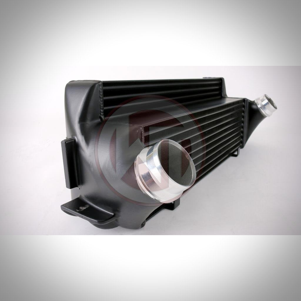 Der Wagner Tuning Evo 2 Competition Ladeluftkühler passend für BMW F2x, F3x verfügt über einen schwarzen Ladeluftkühler mit zwei silbernen Einlass-/Auslassrohren, dargestellt auf weißem Hintergrund.