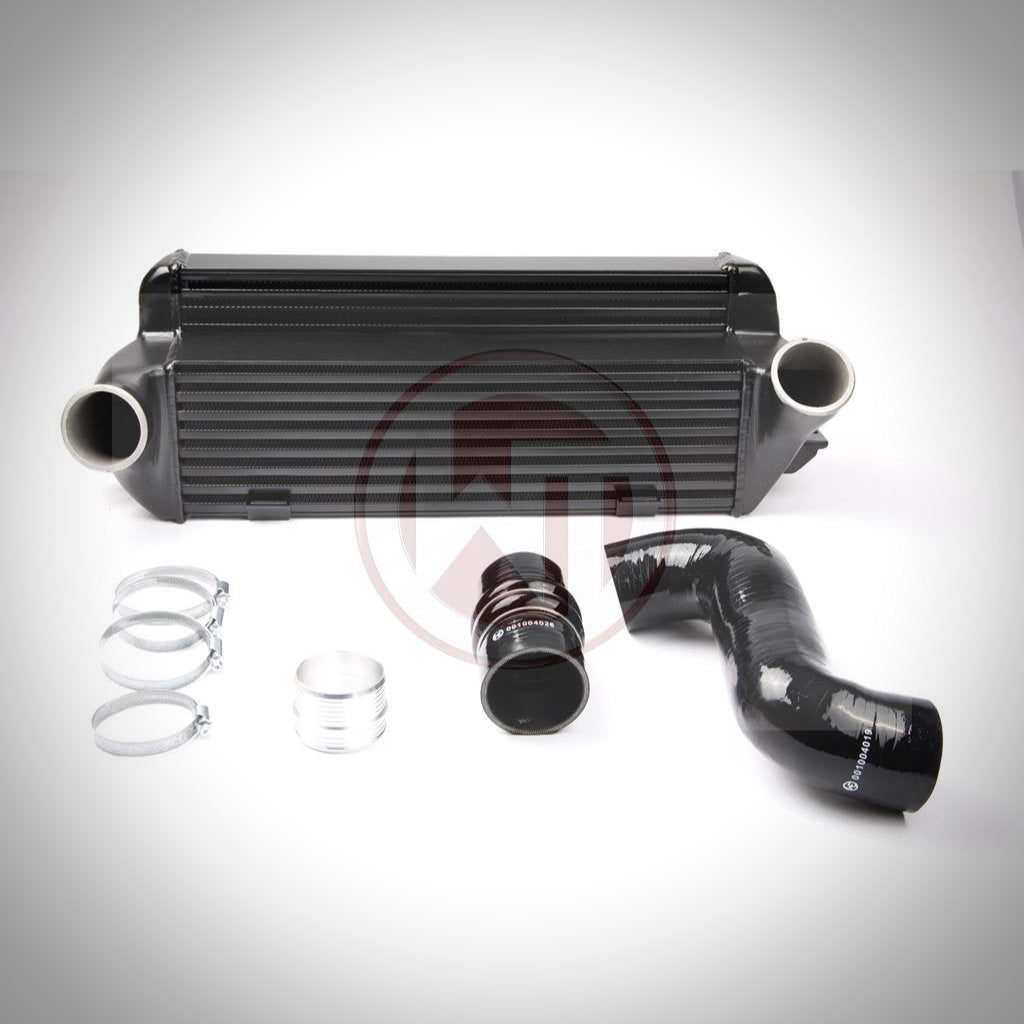 Das Wagner Tuning Evo 2 Competition Ladeluftkühler-Kit passend für BMW 135i, 1er M Coupé und 335i(x) N54/N55 E-Serie umfasst Klemmen, Kupplungen und einen schwarzen Silikonschlauch, abgebildet auf weißem Hintergrund.