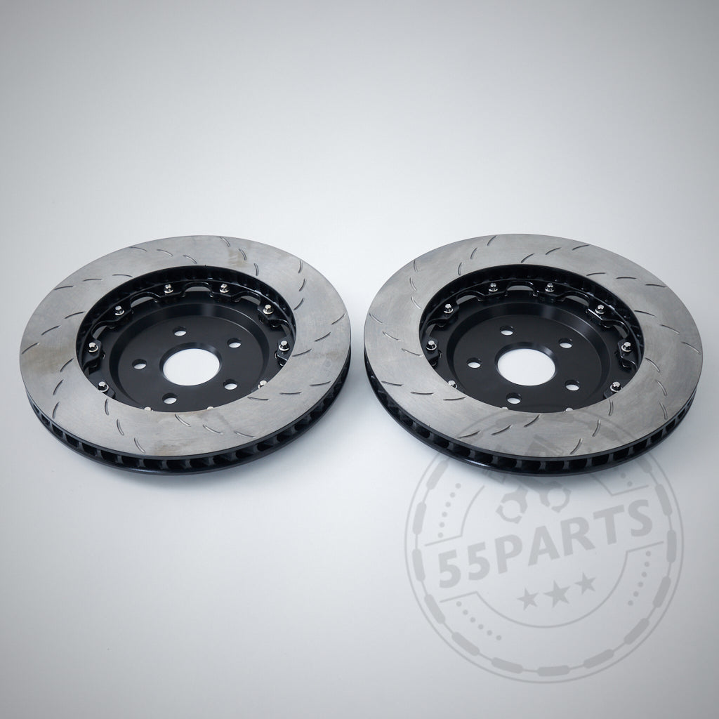 Zwei belüftete, geschlitzte Carbopad 380-mm-Bremsscheiben passend für BMW M2/M3/M4 F8x sind auf hellgrauem Hintergrund abgebildet. Die schwimmend gelagerten Scheiben eignen sich sowohl für den Straßen- als auch für den Rennstreckeneinsatz. Wasserzeichen „55Parts“ sichtbar.