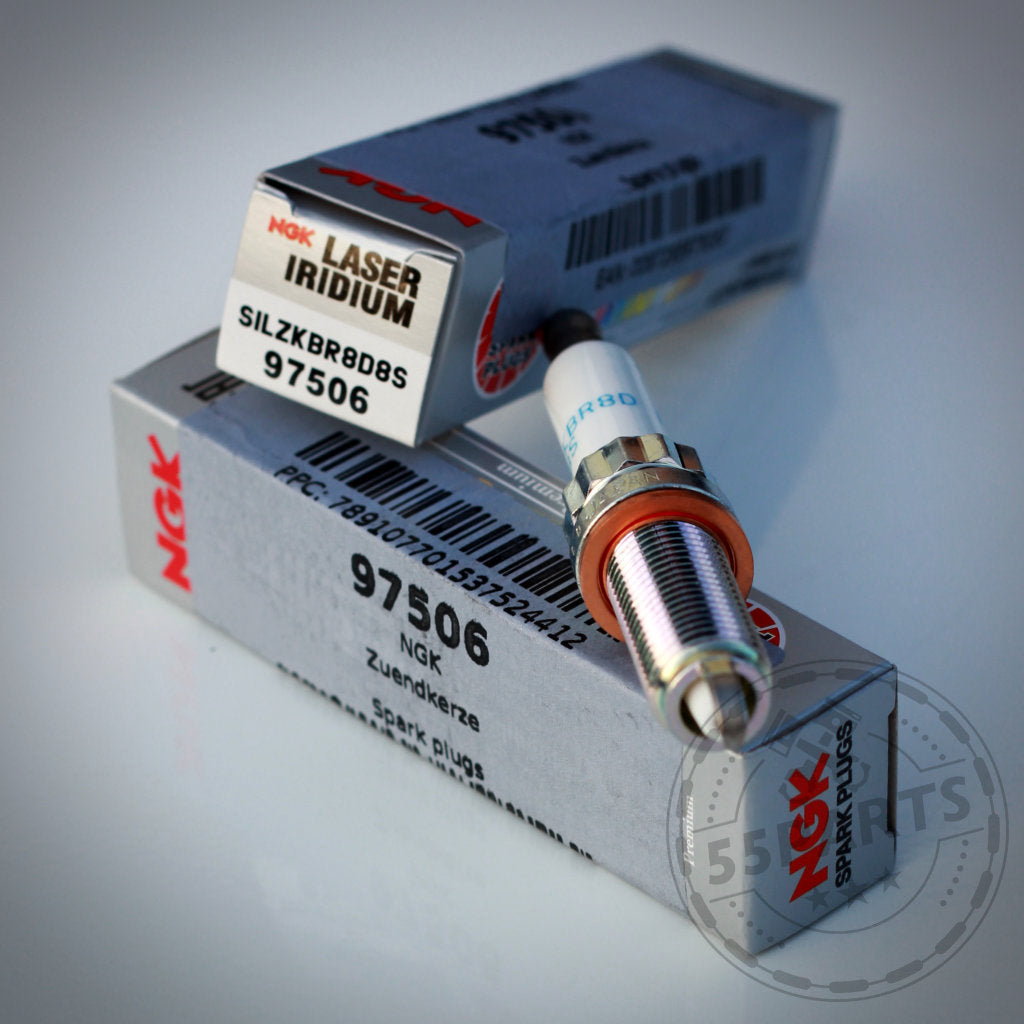 Das Zündkerzen-Set NGK 97506 (SILZKBR8D8S) von NGK wird in der Markenverpackung gezeigt, im Hintergrund ist ein zusätzlicher Karton zu sehen.