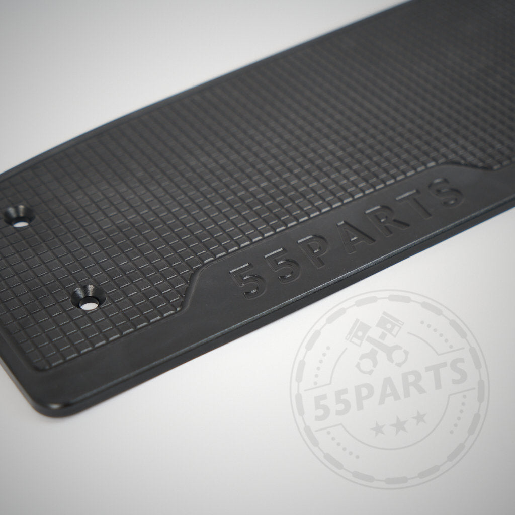 Elegante schwarze Aluminium-Fußstützenablage mit Logo und zwei Schraubenlöchern, passend für die BMW Modelle F2x, F3x und F8x. Strukturierte Oberfläche auf hellem Hintergrund – ideal für die Aufwertung des Fußraums Ihres BMW.