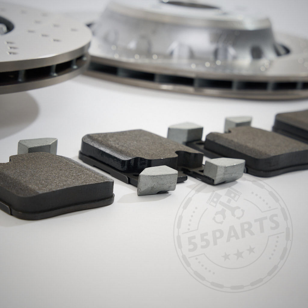 Nahaufnahme des 55Parts-Spezials: Bremsen (Upgrade) Set Hinterachse F-Serie für blaue Bremse F8x M2, M3, M4 auf einer weißen Oberfläche, die das BMW-Hinterradbremsen-Upgrade mit dezentem Logo im Hintergrund zeigt.