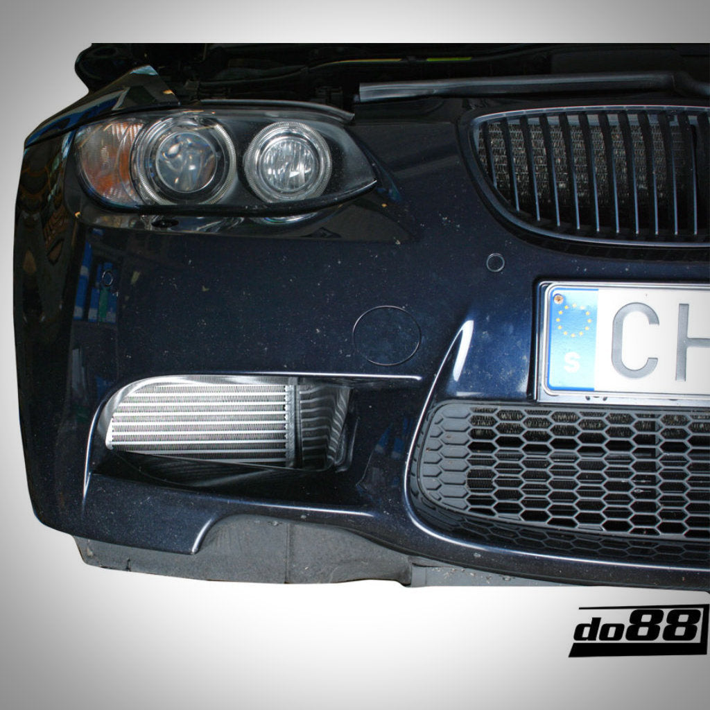 Nahaufnahme eines BMW E9x M3 S65 mit sichtbarem do88 DKG und Schaltgetriebe-Ölkühler Rennsport, mit Scheinwerfern, Kühlergrill, Nummernschild und verbessertem Kühlsystem.