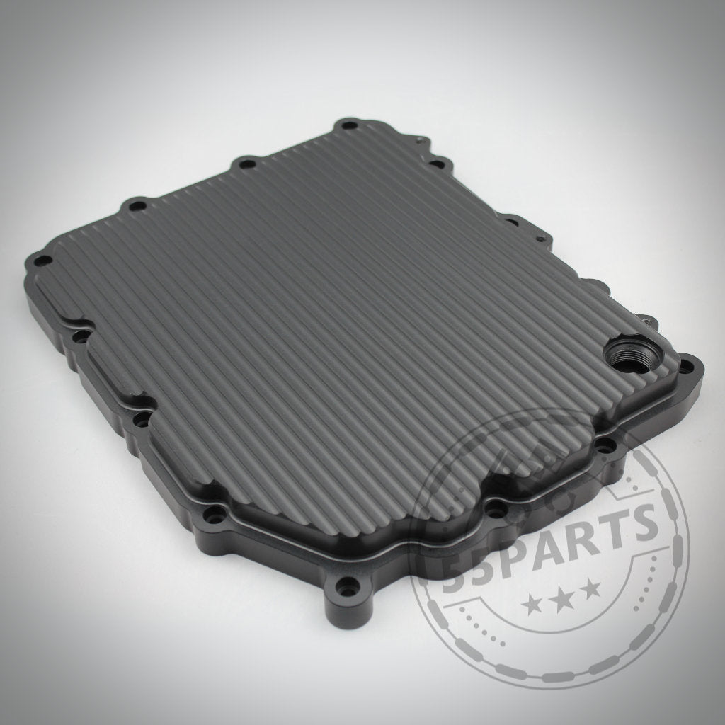 Exklusiv bei 55Parts: Schwarze, gerippte Aluminium-Ölwanne passend für BMW 1/335i, M2(c), M3, M4, M5 und M6 (E- und F-Serie DKG GS7D36BG) auf hellem Hintergrund mit dem 55Parts-Logo in der Ecke.