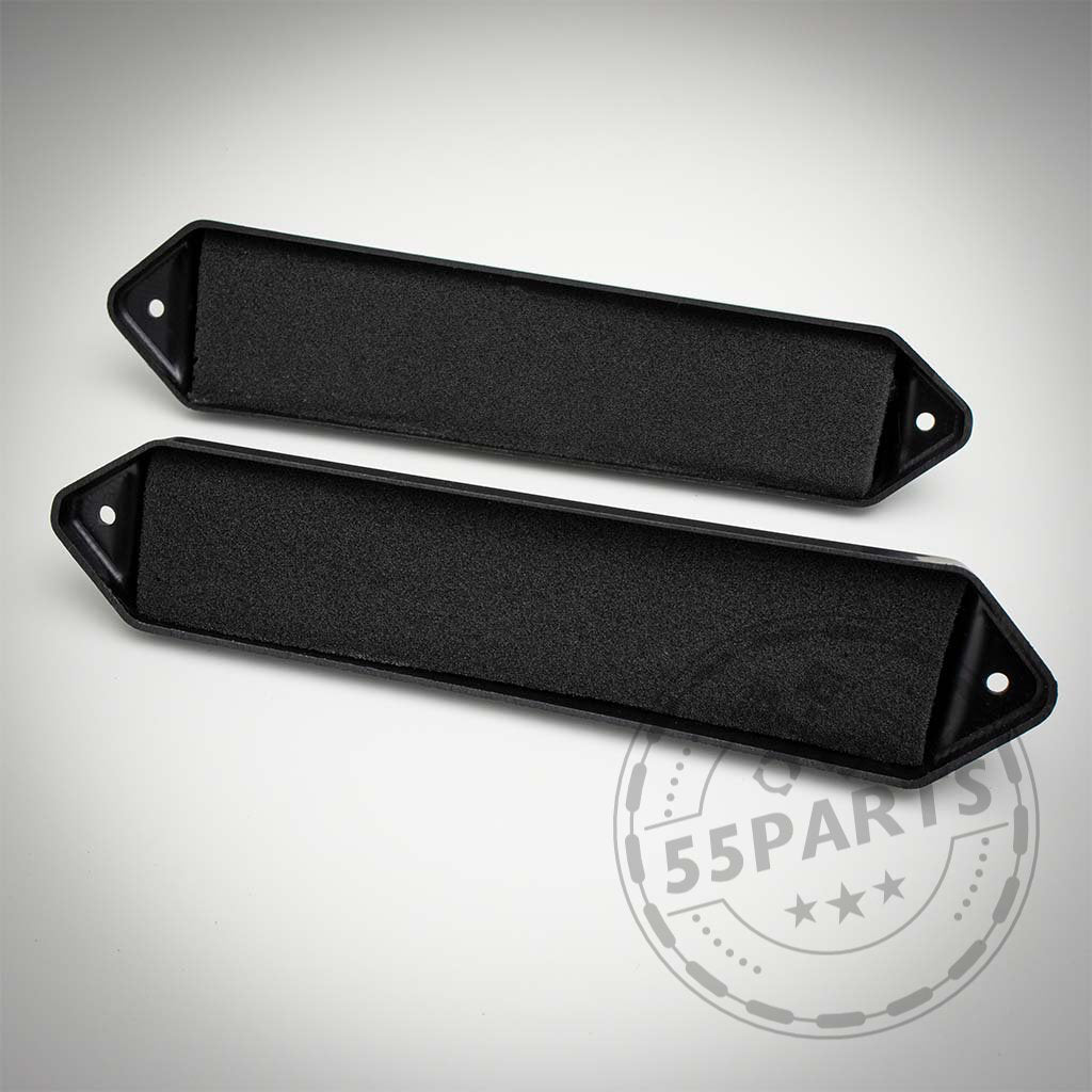 Zwei schwarze, rechteckige Kunststoffteile mit abgewinkelten Enden und Löchern, gekennzeichnet als Bannik Engineering Mikrofilter Delete Gehäuse passend für BMW E8x/E9x 1er und 3er (55Parts Exclusive), sind auf einer weißen Oberfläche platziert.