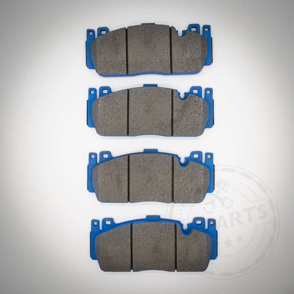 Vier graue Endlos-Bremsbeläge mit blauen Trägerplatten für die 6-Kolben-BMW-Performance-Bremssättel (M2C vorn, M4 CCB, M5) sind vertikal auf hellem Untergrund angeordnet und sorgen für optimale Bremsleistung.