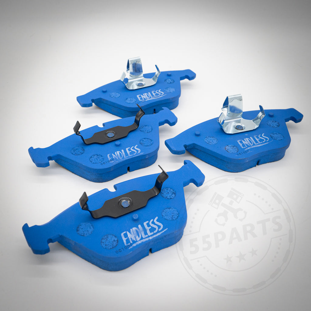 Vier blaue Endless Bremsbeläge für 1-Kolben Schwimmsattel, passend für BMW 1er M Coupe, M3, E9x 325d-335i, mit Metallclips auf weißem Untergrund – ideal für Rennstreckenfahrten.
