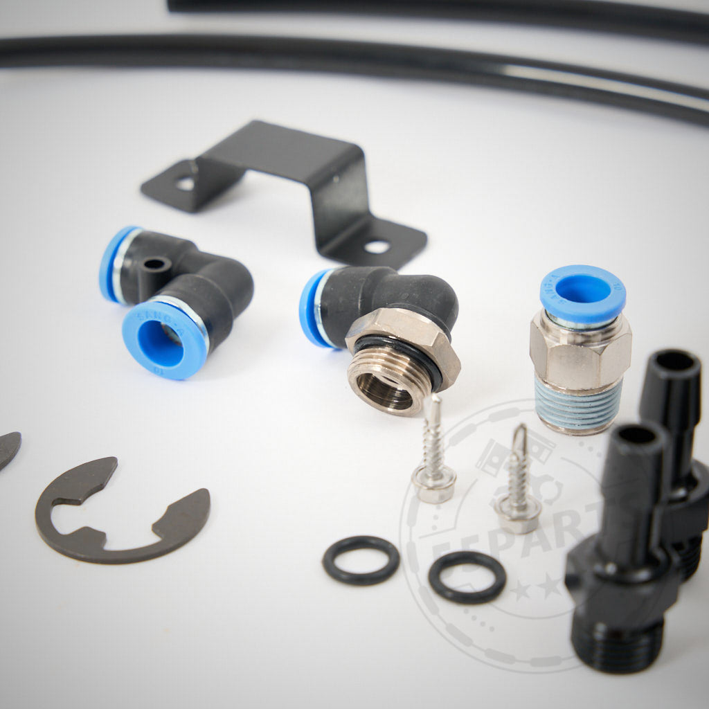 Verschiedene exklusive 55Parts-Anschlüsse, Unterlegscheiben und Halterungen für das externe PCV-System „Leerlaufseite“ passend für BMW 135i, 1er M Coupé und 335i(x) N54 werden auf einer weißen Oberfläche angezeigt.