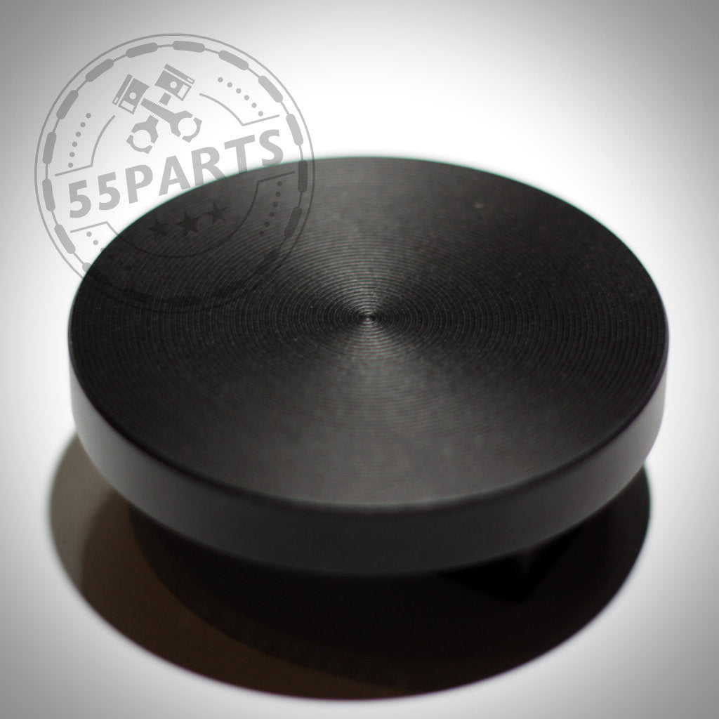 Der 55Parts Jackpad Wagenheberadapter Anhebehilfe Aufbockhilfe passend für BMW ist ein schwarzer, runder Kunststoffadapter mit strukturierter Oberseite, abgebildet auf weißem Hintergrund.