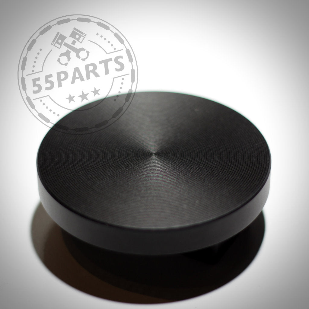 Schwarze, runde Metallplatte mit Rillen und 55Parts-Logo oben links. Jackpad Wagenheberadapter Anhebehilfe Aufbockhilfe, CNC-gefräst, passend für BMW.