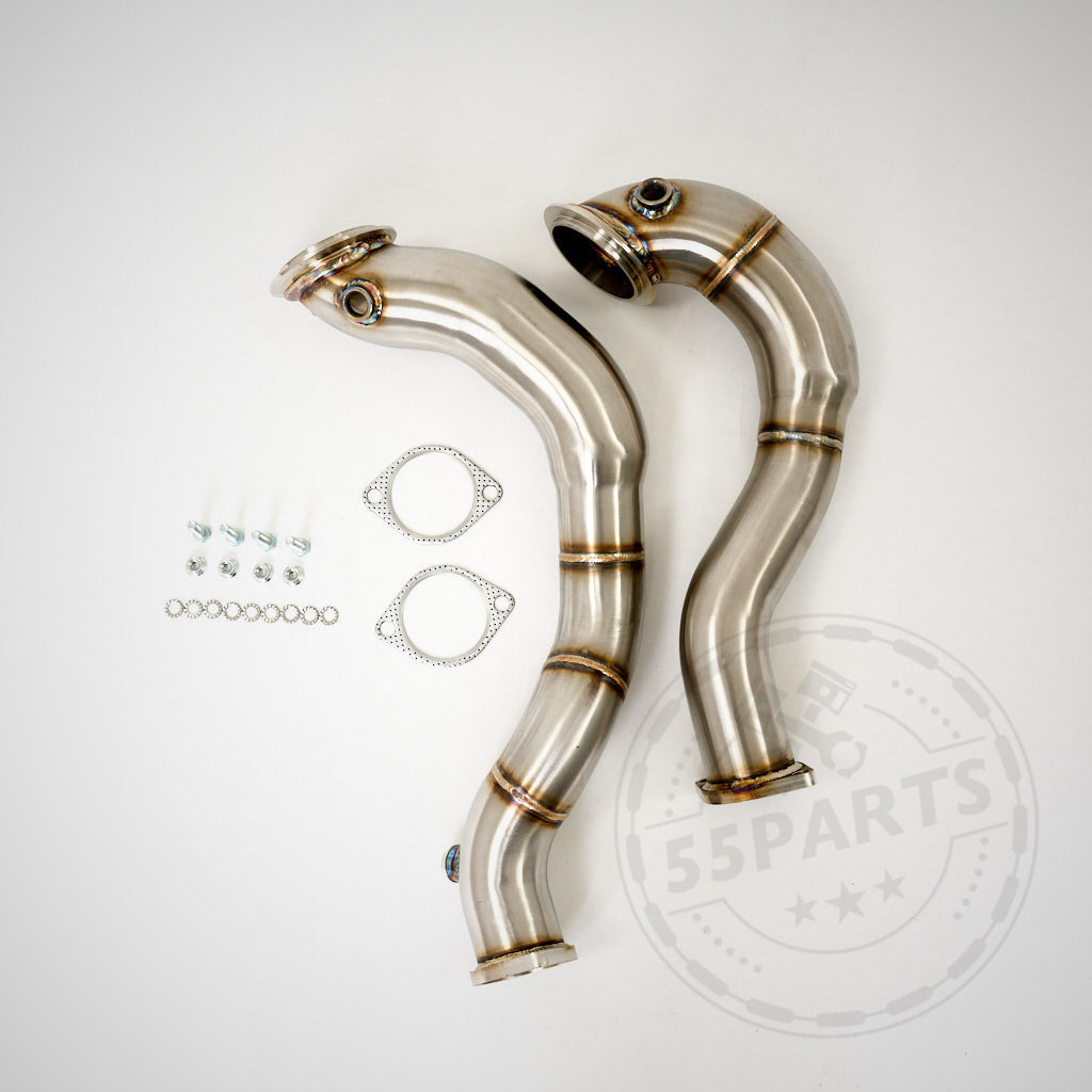 Zwei 3-Zoll-Downpipes ohne Katalysator für N54-Motoren BMW E92, E90, E91 335i X-Drive, abgebildet mit mitgelieferten Dichtungen, Schrauben und Unterlegscheiben auf weißem Hintergrund.