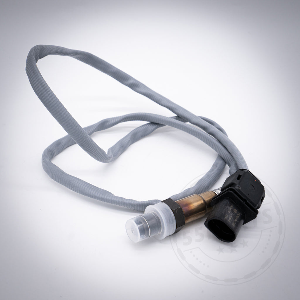 Graue Lambdasonde(n) Regelsonde(n), passend für BMW 135i, 1er M Coupé und 335i(x) N54; verfügt über einen schwarzen Stecker und eine Schutzkappe, gewickelt auf weißem Hintergrund.