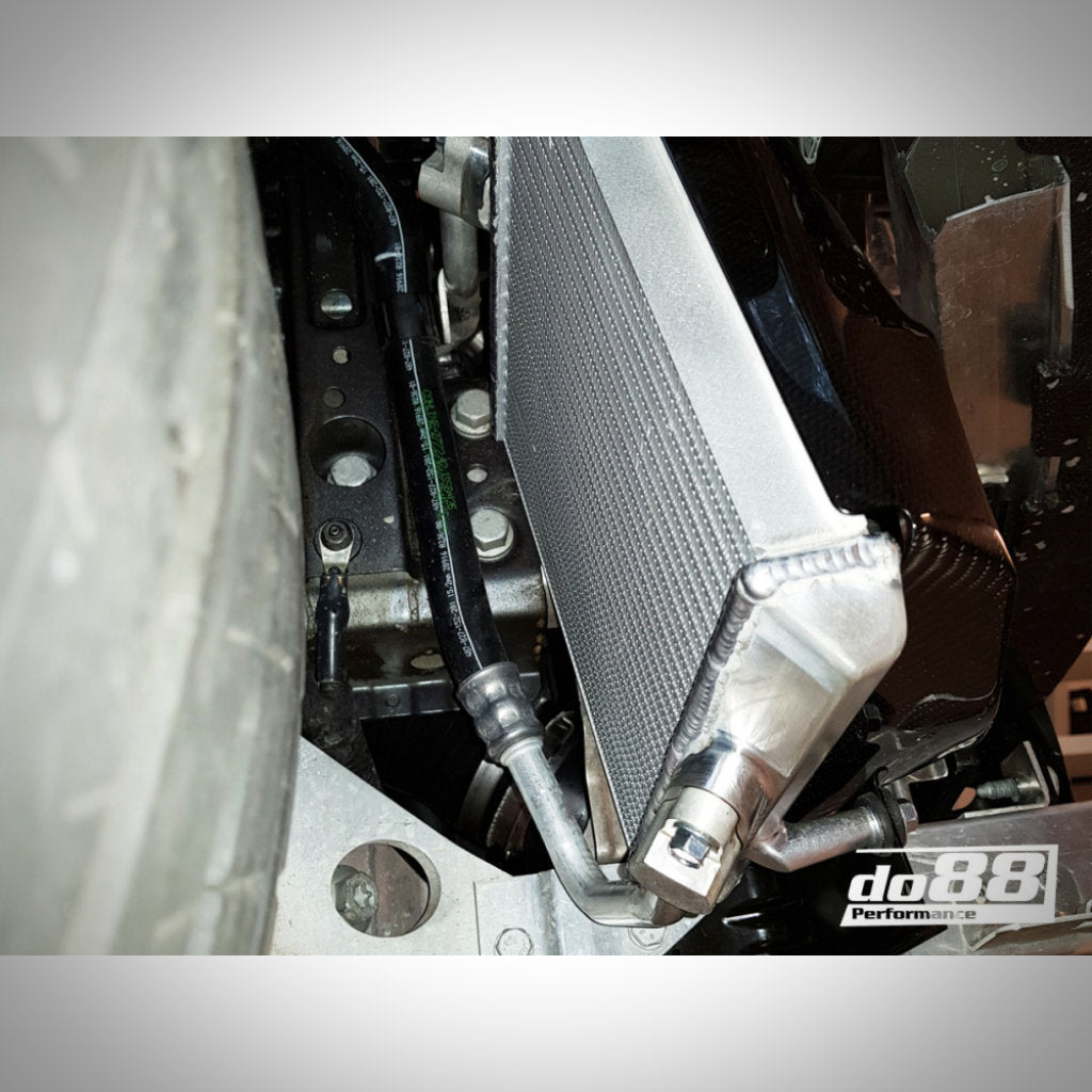 Nahaufnahme eines Autokühlers und von Schläuchen mit einem do88-Logo – präsentiert den do88 Motorölkühler Rennsport, passend für BMW F87 M2, perfekt für Leistungskühlungs-Upgrades oder den Einsatz auf der Rennstrecke.