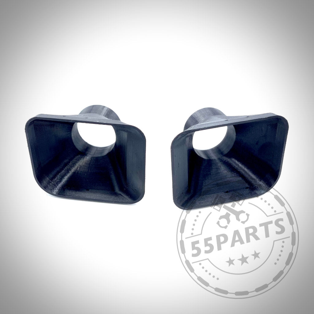 Zwei schwarze, quadratische Kunststoffkomponenten mit kreisförmigen Öffnungen, dargestellt auf weißem Hintergrund. 55Parts Exclusive Bremsbelüftungsset, konzipiert passend für BMW E36 Modelle (inkl. M3), ideal für Rennstrecken-Leistungssteigerungen.