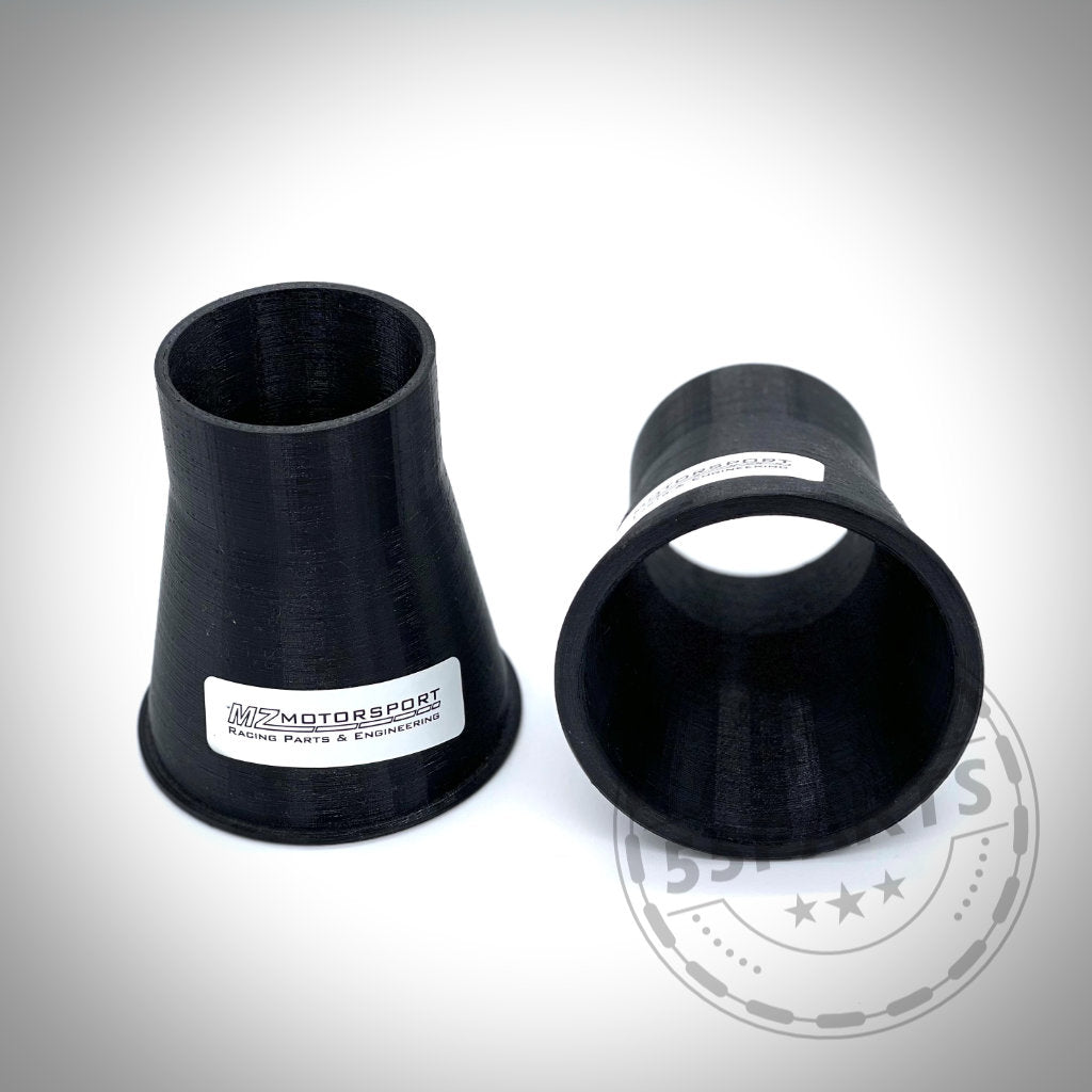 Auf weißem Hintergrund sind zwei schwarze Kunststoffadapter, Teil des „Bremsbelüftungssets passend für BMW 3er E9x mit M Paket“, abgebildet.