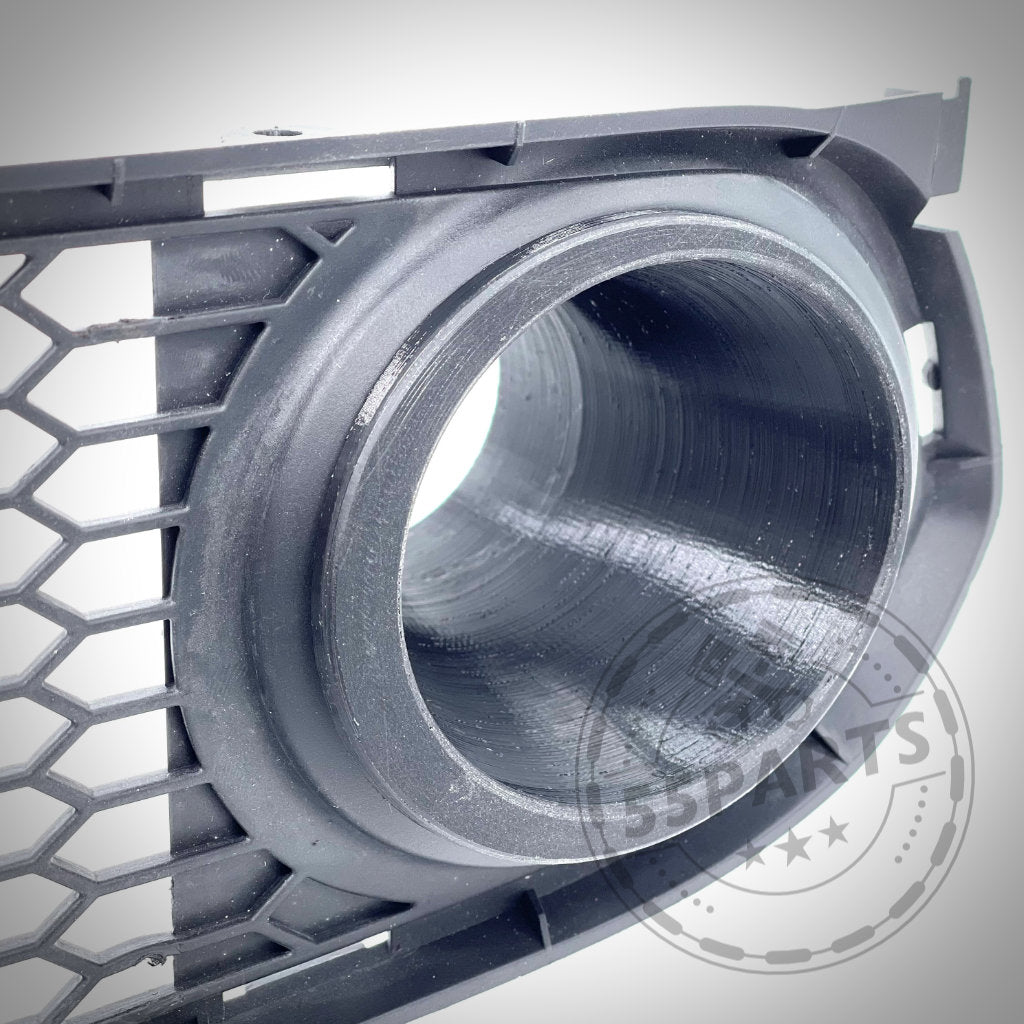 Nahaufnahme eines schwarzen Kühlergrills mit runder Ansaugung und Wabengitter, wie das 55Parts Exclusive Bremsbelüftungsset passend für BMW 3er E9x mit M Paket – auf Leistung ausgelegt.