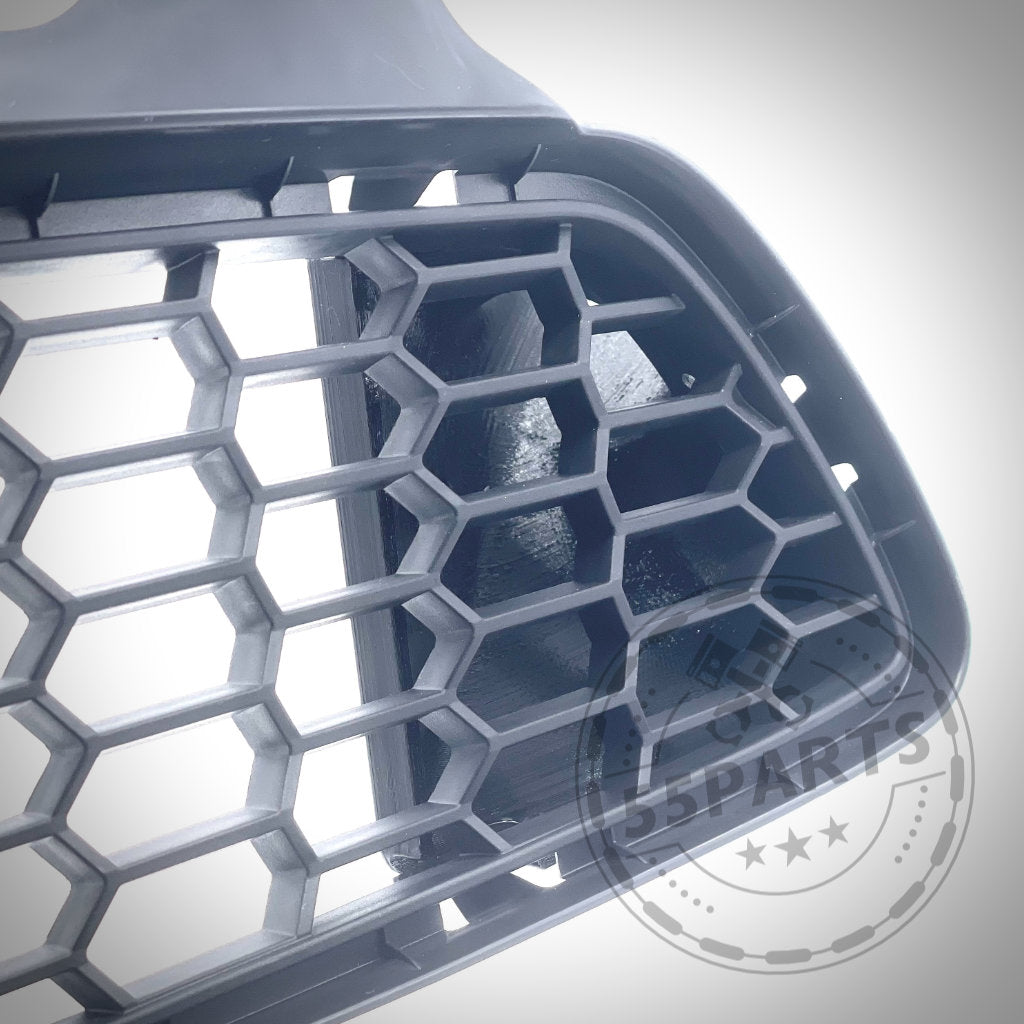 Nahaufnahme eines schwarzen Wabengrills aus dem 55Parts Exclusive Bremsbelüftungsset passend für BMW M3/M4 F80, F82, F8x S55, mit einem 55Parts-Logo-Wasserzeichen in der unteren rechten Ecke – ideal für den Hochleistungseinsatz.