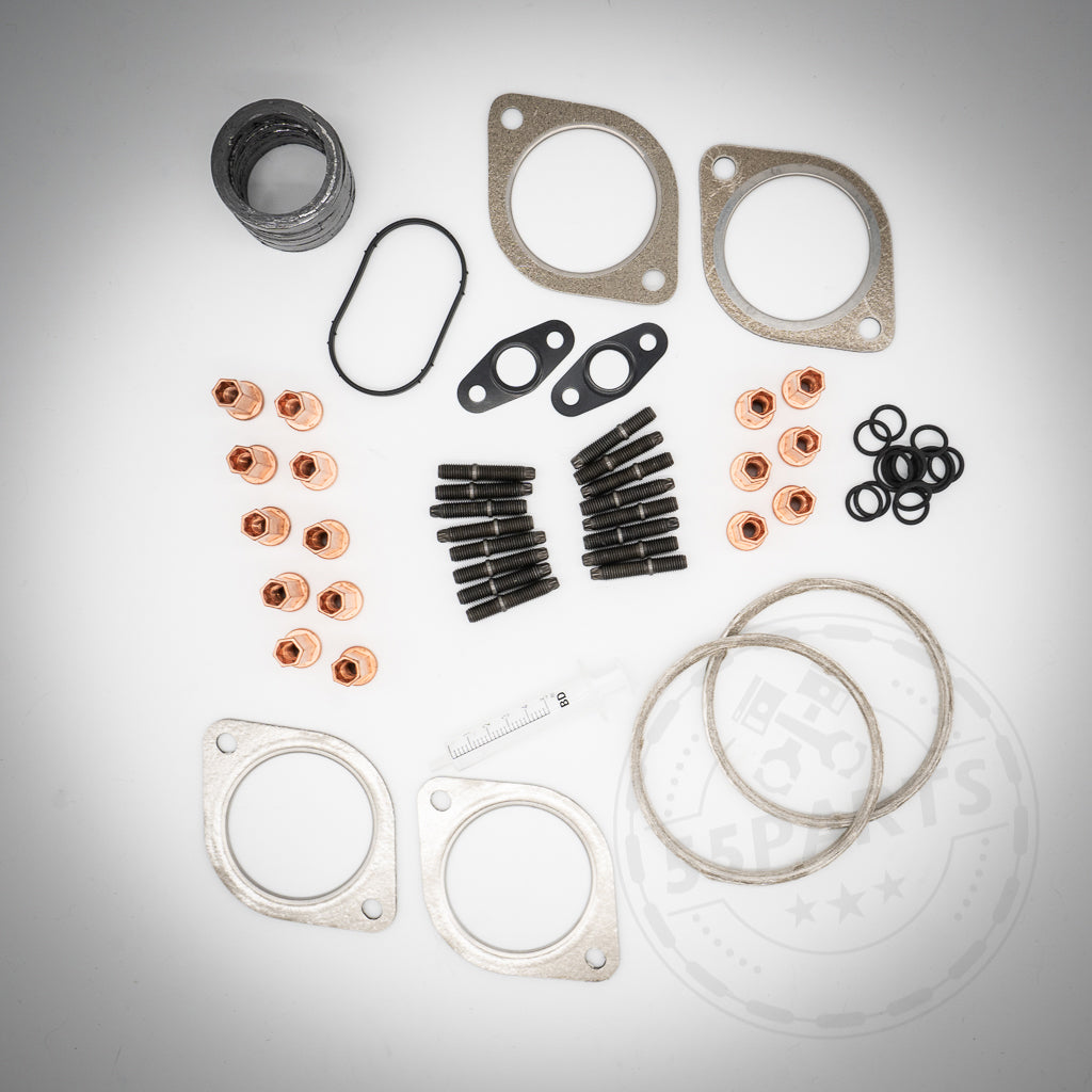 55Partss Turbolader-Einbauset passend für BMW 135i, 1er M Coupe, 335i(x) N54 mit sortierten Anbauteilen auf weißem Hintergrund angeordnet.