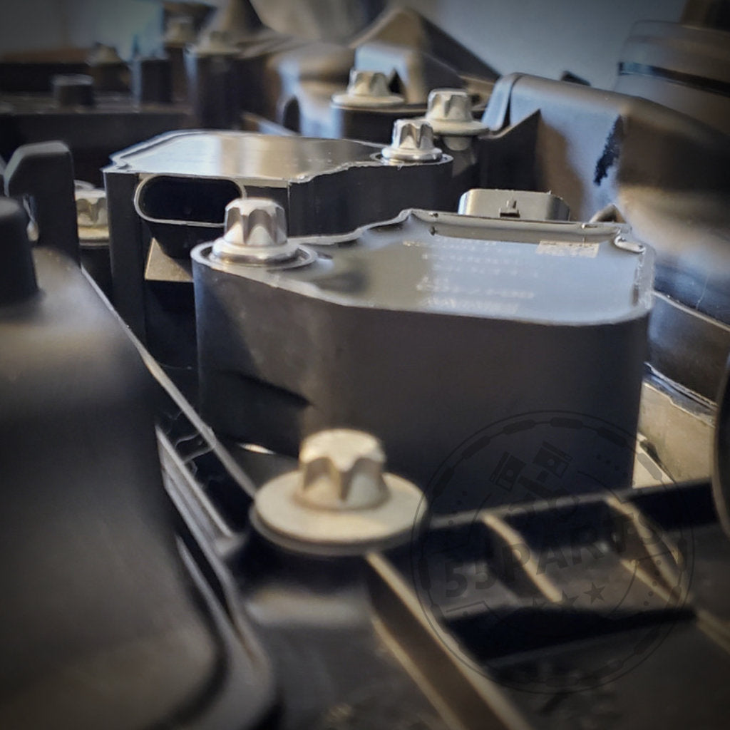 Nahaufnahme der schwarzen mechanischen Komponenten mit silbernen Schrauben, mit dem exklusiven Nexsys Motorsport 55Parts: NexSys B58 Zündspulen-Upgrade-Kit passend für BMW S55- und N55-Motoren (E8x, E9x, F2x, F3x, F8x), das zur Leistungssteigerung entwickelt wurde.