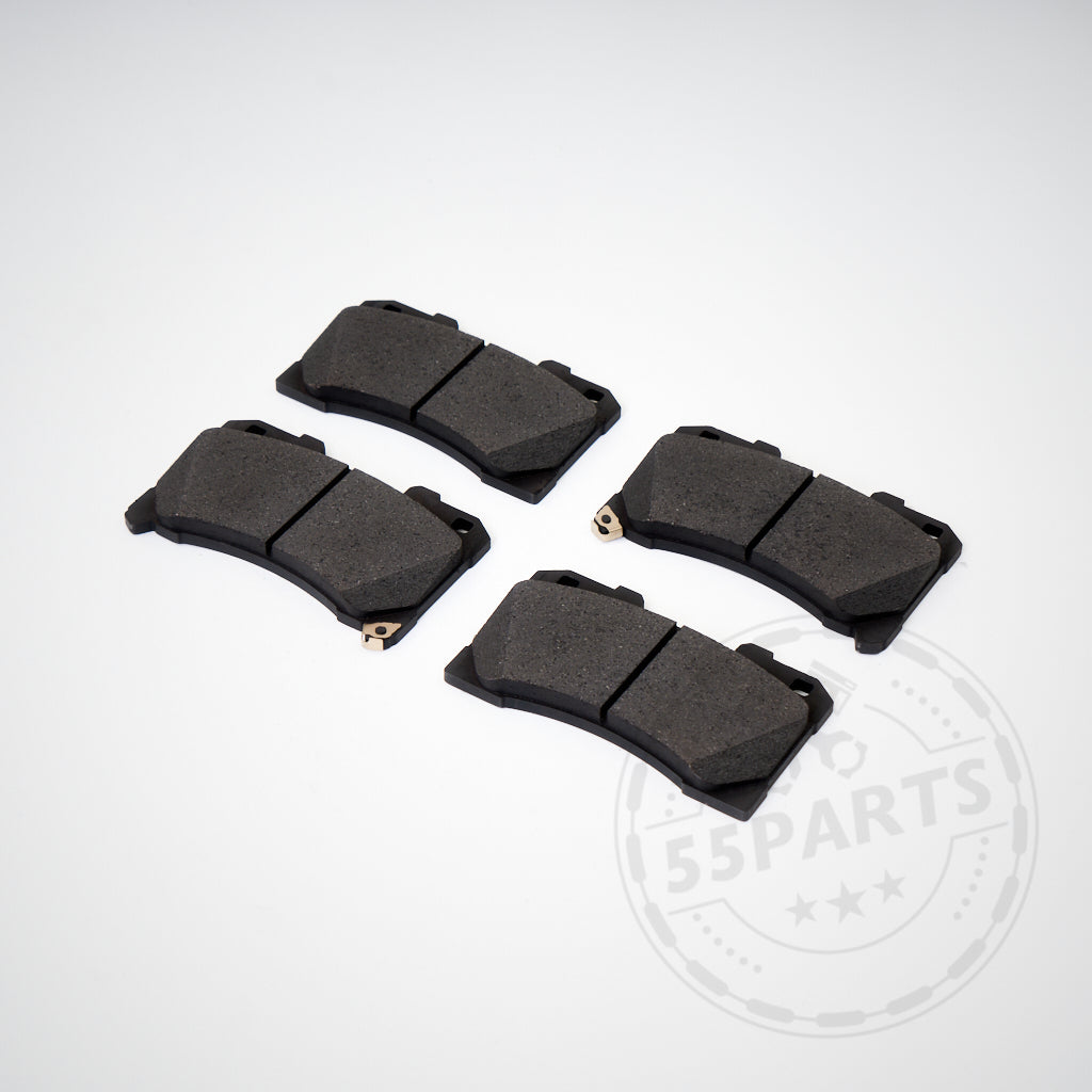 Vier Original Bremsbeläge passend für Toyota Yaris GR, in Schwarz, liegen als Verschleißteile auf weißem Hintergrund mit zartem Wasserzeichen.