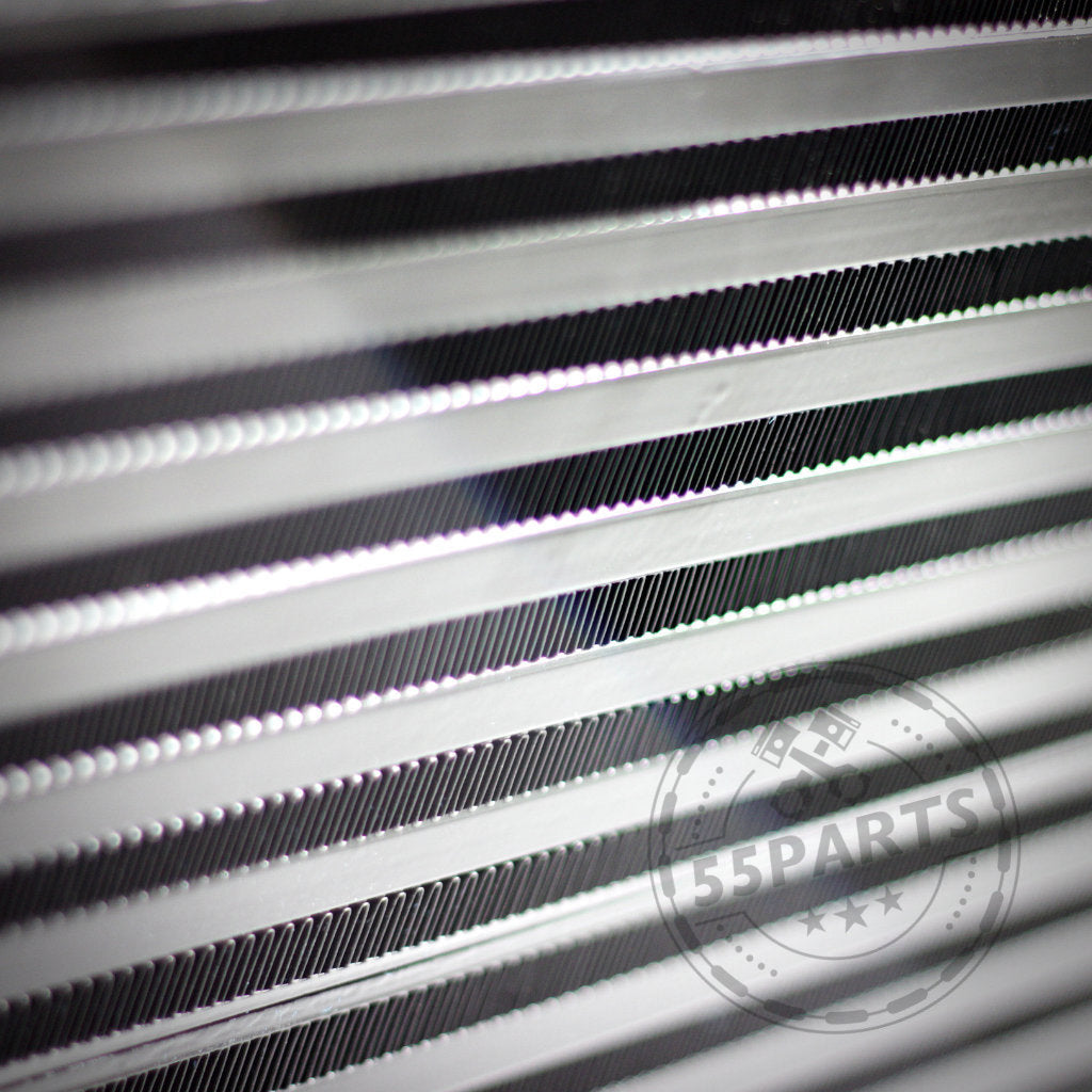 Nahaufnahme der metallischen Kühlrippen aus dem 55Parts-Special: 7,5-Zoll-Renn-Ladeluftkühler passend für BMW 135i, 1er M Coupé und 335(x)i N54/N55 E-Serie (inkl. Teilegutachten), mit einem dezenten 55Parts-Wasserzeichen.