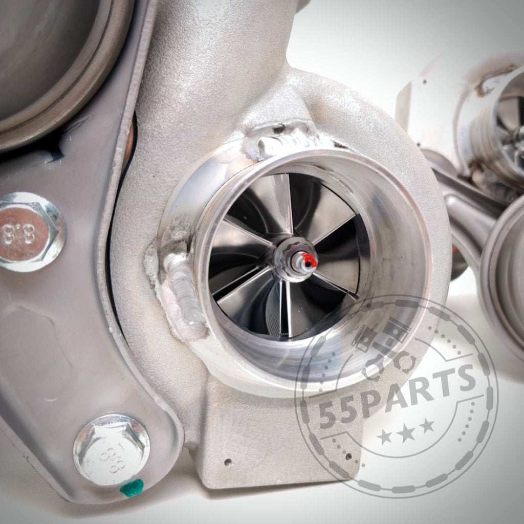 Nahaufnahme eines Pure Turbos Pure Stage 2 Casted Turbo passend für BMW 135i, 1er M Coupé und 335i(x) N54; metallische Turbinenschaufeln unterstreichen Qualität und Wert. Dezentes 55Parts-Wasserzeichen ist sichtbar.