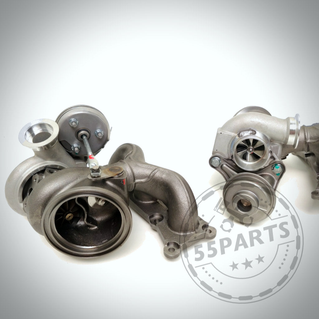 Zwei Pure Stage 2 Casted Turbos von Pure Turbos, passend für BMW 135i, 1er M Coupe, 335i(x) N54, abgebildet auf einer weißen Oberfläche mit einem halbtransparenten Pure Lader-Logo-Overlay, um ihr hervorragendes Preis-Leistungs-Verhältnis hervorzuheben.