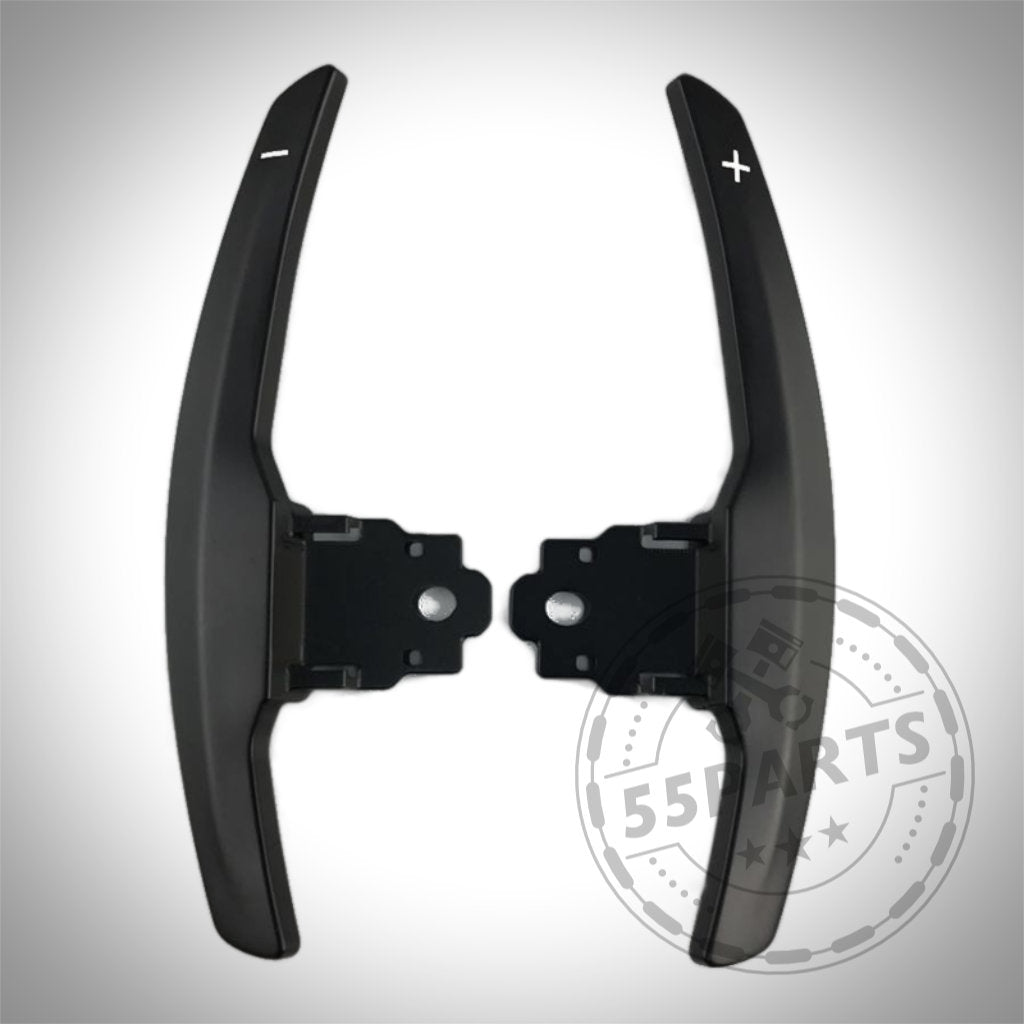 55Parts Aluminium/Carbon Schaltwippen passend für BMW 1/235, 40i, 3/435, M2, M3 & M4 F/G-Serie in Schwarz mit Plus/Minus-Symbolen auf weißem Hintergrund dargestellt.