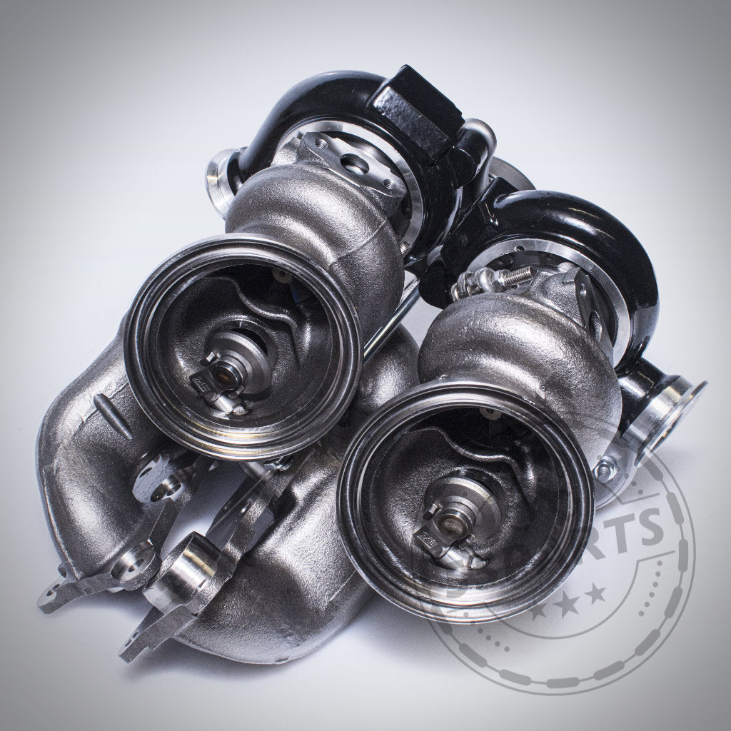 Zwei Turbosystems Upgrade Turbolader passend für BMW 135i, 1er M Coupé, 335i(x) und Z4 35I(S) N54 verfügen über schwarze Gehäuse und werden nebeneinander auf hellem Hintergrund angezeigt.