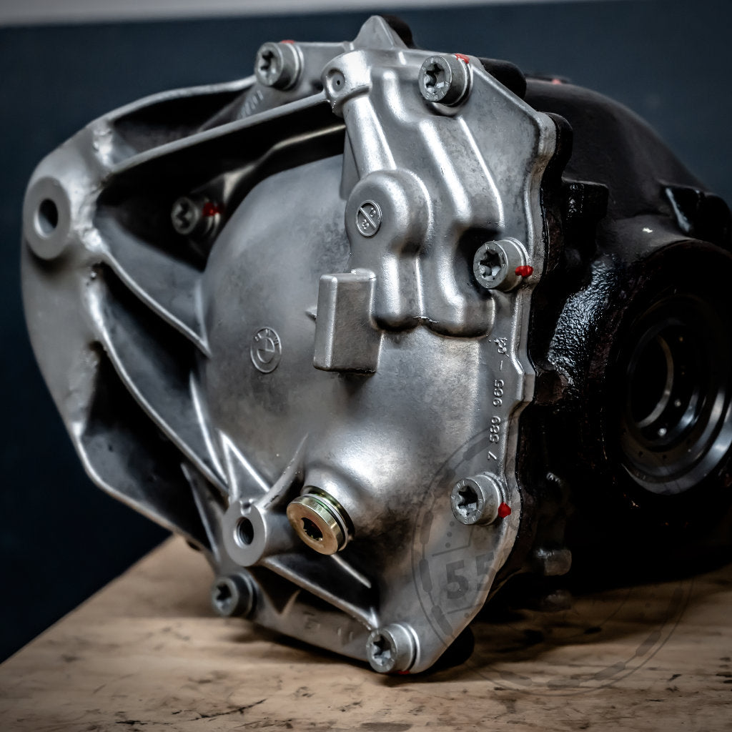 Nahaufnahme eines speziellen mechanischen Drexler-Lamellensperrdifferentials & Westwood Performance, das für fast alle BMW-Modelle entwickelt wurde und auf Holz mit sichtbaren Schrauben und aufwendigen Details ruht.