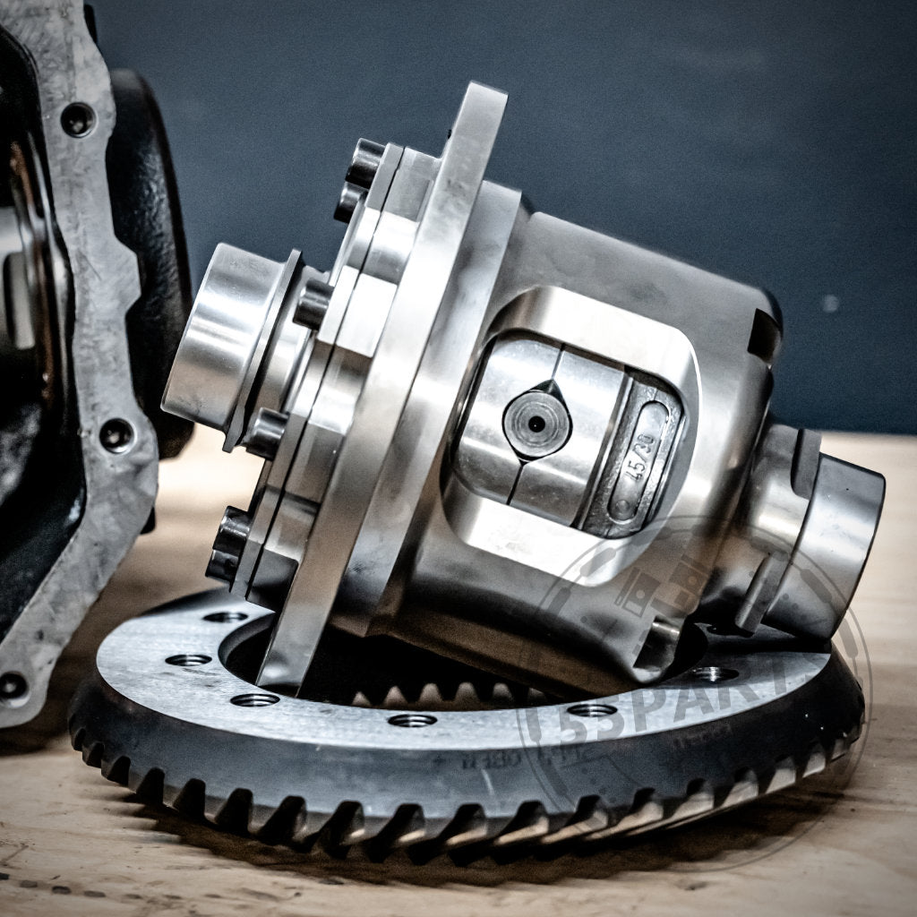 Nahaufnahme eines glänzenden 55Parts & Westwood Performance Drexler Lamellensperrdifferentials auf Holz mit dunklem Hintergrund – ein ideales mechanisches LSD-Upgrade für fast alle BMW-Modelle.