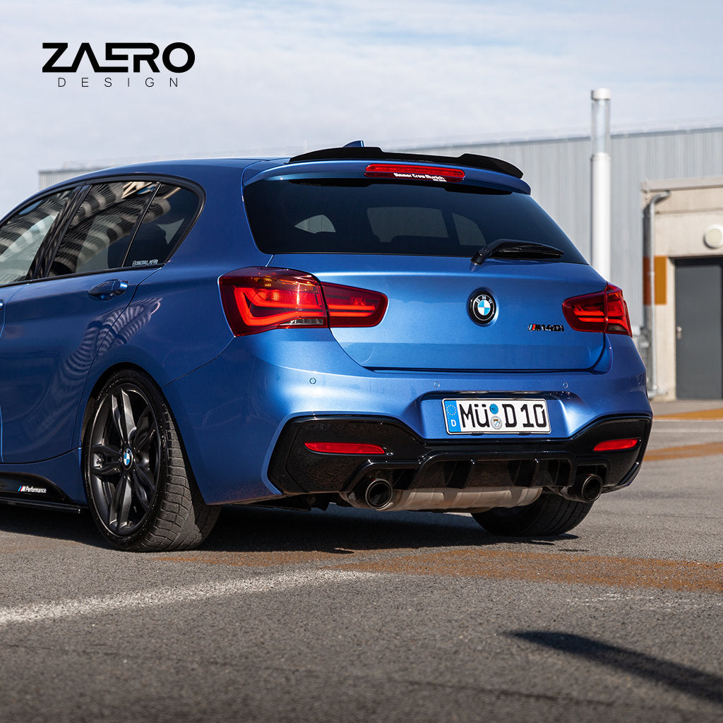 Blauer BMW M140i Schrägheck im Freien, oben links zeigt ZAERO-Branding; Ausgestattet mit einem glanz schwarzen ZAERO Evo-1 Diffusor passend für BMW M135i M140i F2x plus Carbon Anbauteilen für eine markante Optik.