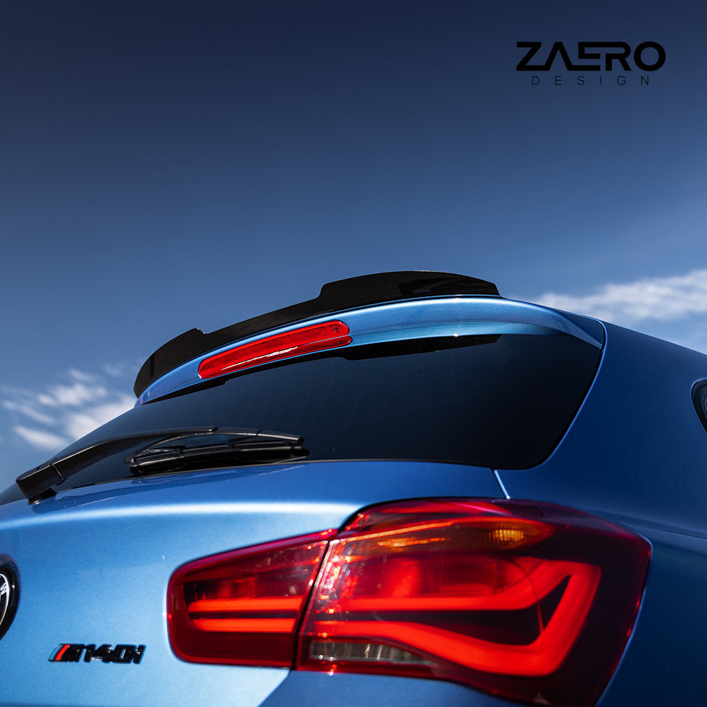 Nahaufnahme des Hecks eines blauen BMW M140i mit einem ZAERO Heckspoiler passend für BMW F2x unter einem klaren blauen Himmel, mit dem ZAERO-Logo.