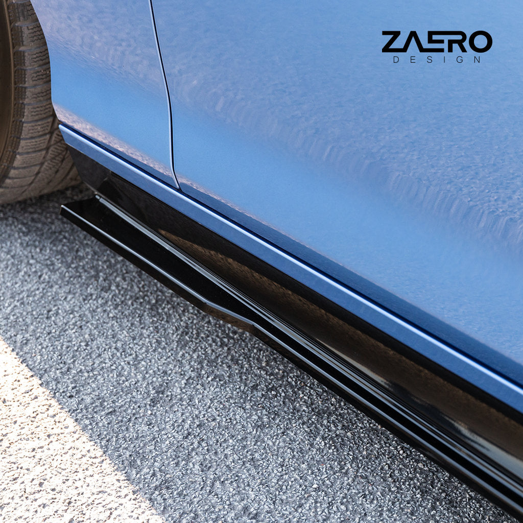 Nahaufnahme der ZAERO Evo-1-Seitenschweller passend für BMW F2x in glänzendem Schwarz auf einem auf Asphalt geparkten blauen Auto, mit dem Zastro Design-Logo in der oberen rechten Ecke.