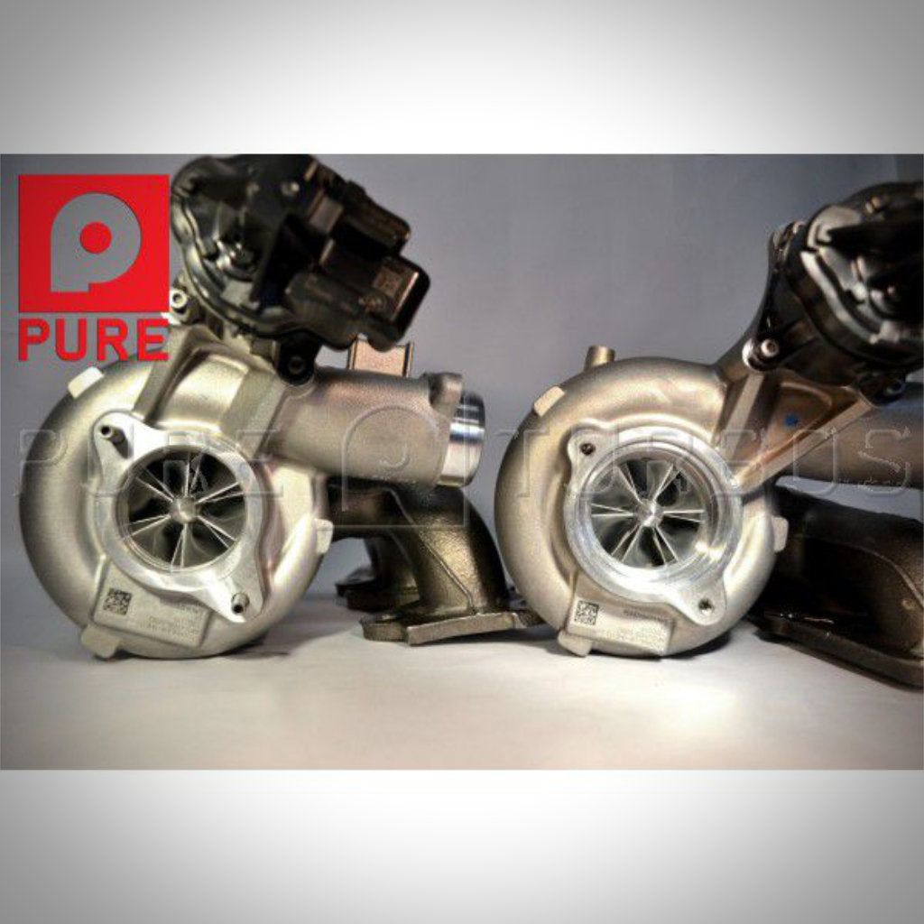 Zwei metallische Turbolader nebeneinander mit dem PURE-Logo oben links, konzipiert als Pure Turbos Stage 2 Upgrade Turbolader passend für BMW M2 Competition, M3 F80 und M4 F8x S55.