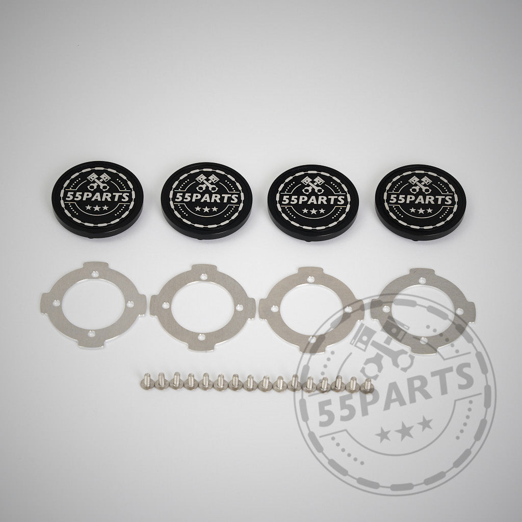 Vier 55Parts CNC-gefräste, verschraubte Radnabendeckel für ProTrack One Felgen, mit vier silbernen Ringen und einer Reihe Metallkugeln, sind auf weißem Grund abgebildet. Die hochwertige Aluminiumkonstruktion unterstreicht dieses stilvolle Zubehör.