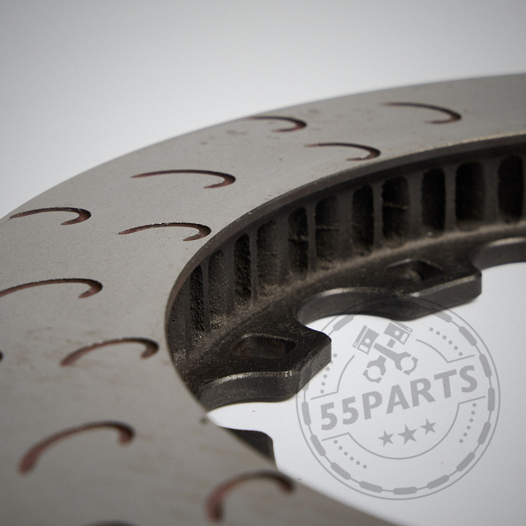 Nahaufnahme einer Metallzahnrad- oder Scheibenbremse mit geschwungenen Rillen und schwachem 55Parts-Wasserzeichen – ideal für BMW-Bremsen und perfekt für die Rennstrecke. Enthält das 55Parts-Special: AP Racing 368 x 36 mm S-Vane-Reibringe.