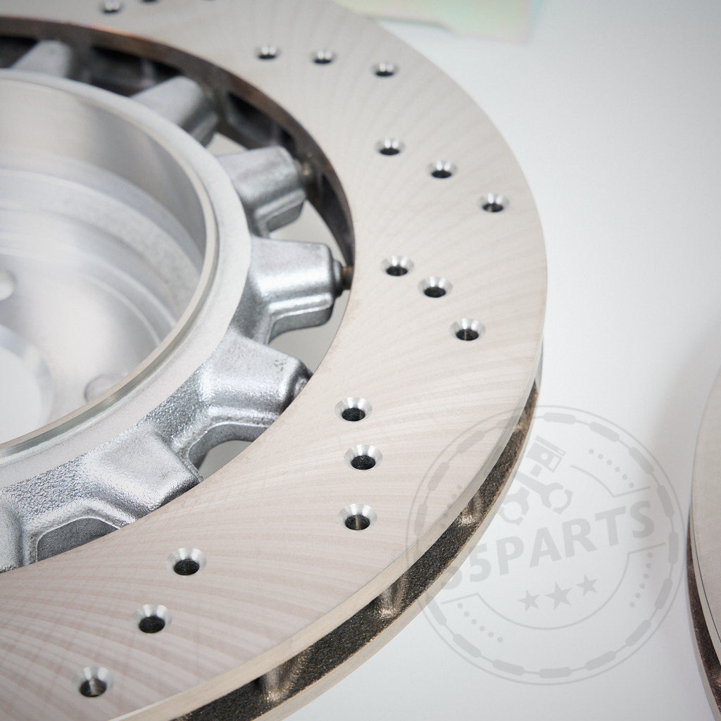 Nahaufnahme eines belüfteten, gebohrten AP Racing CP9449 Big Brake Kit mit einer originalen 380x28 BMW-Scheibe passend für BMW M2, M3 und M4 (F80, F82, F83, F87), dargestellt auf weißem Hintergrund.