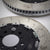 Nahaufnahme von zwei nachträglich belüfteten Schlitzrotoren mit angebrachter Hardware des 55Parts Special: AP Racing Big Brake Kit, ausgestellt auf einer hellen Oberfläche.